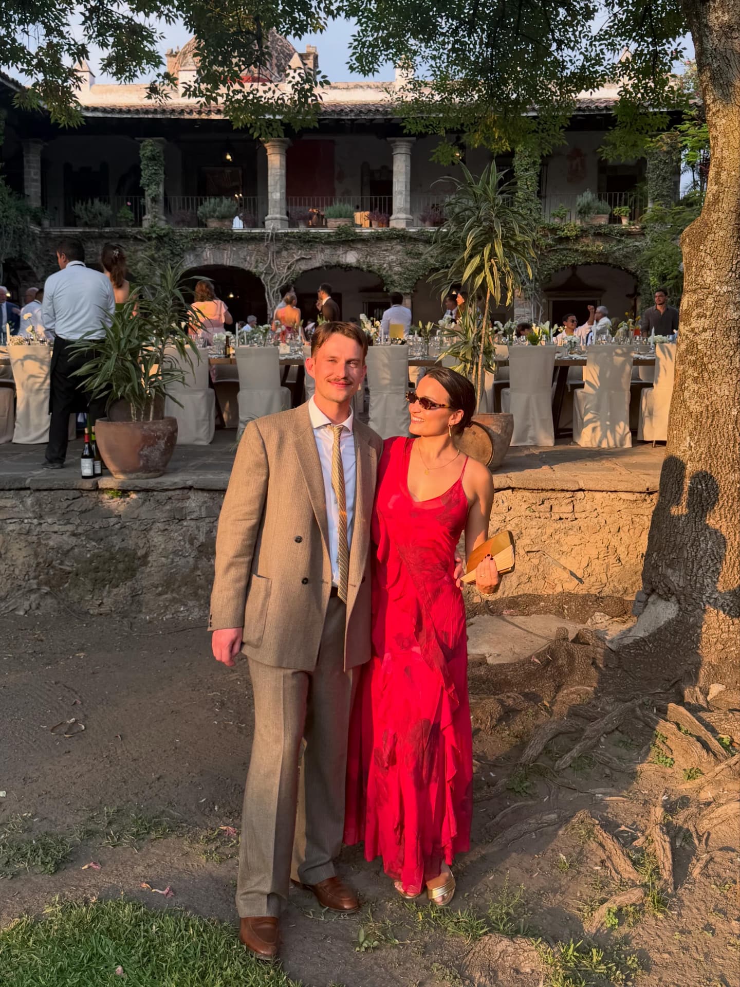 Zoe & Pete dressed up at a wedding in the sun