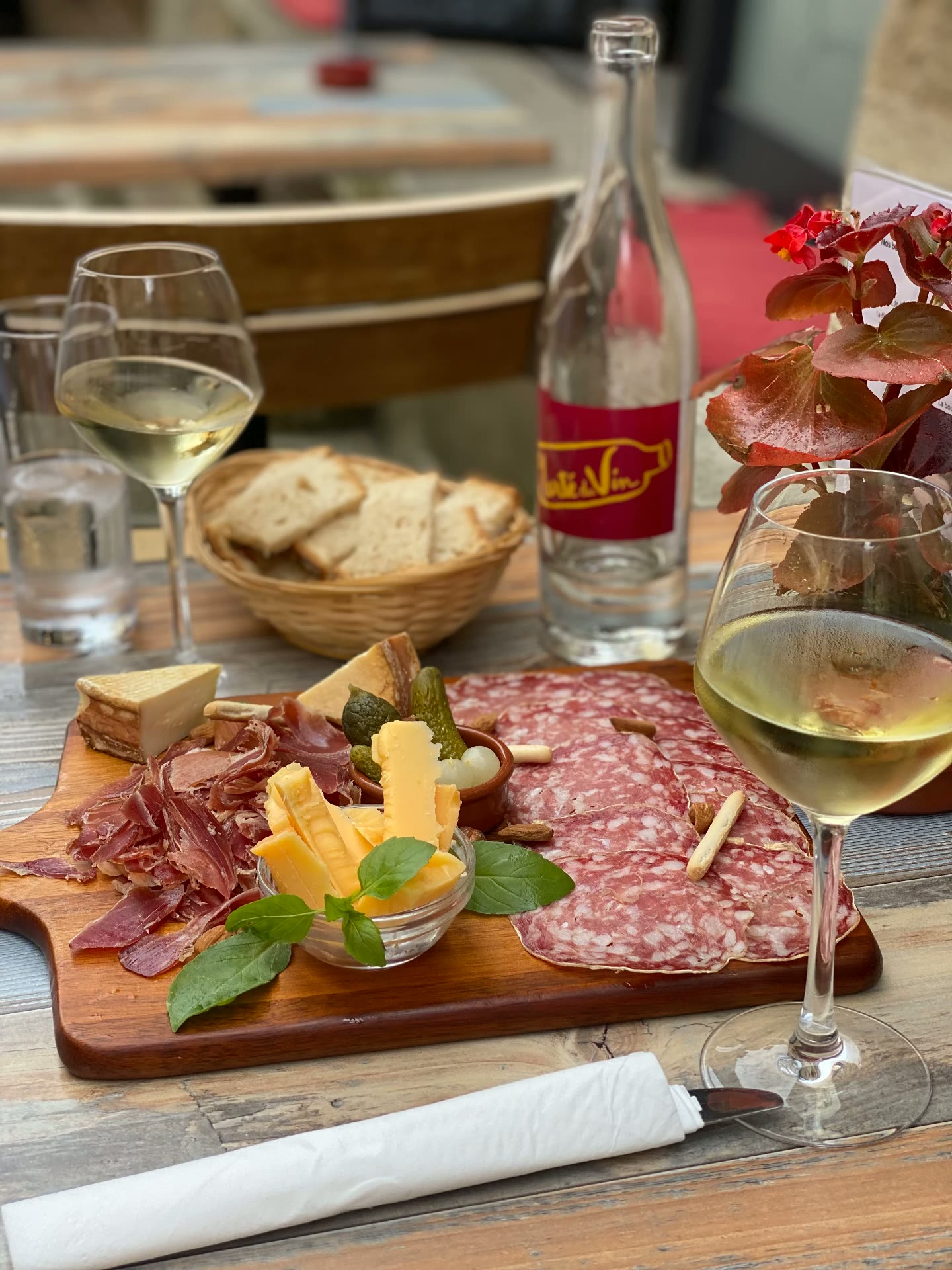 Charcuterie board and white wine at an outdoor table