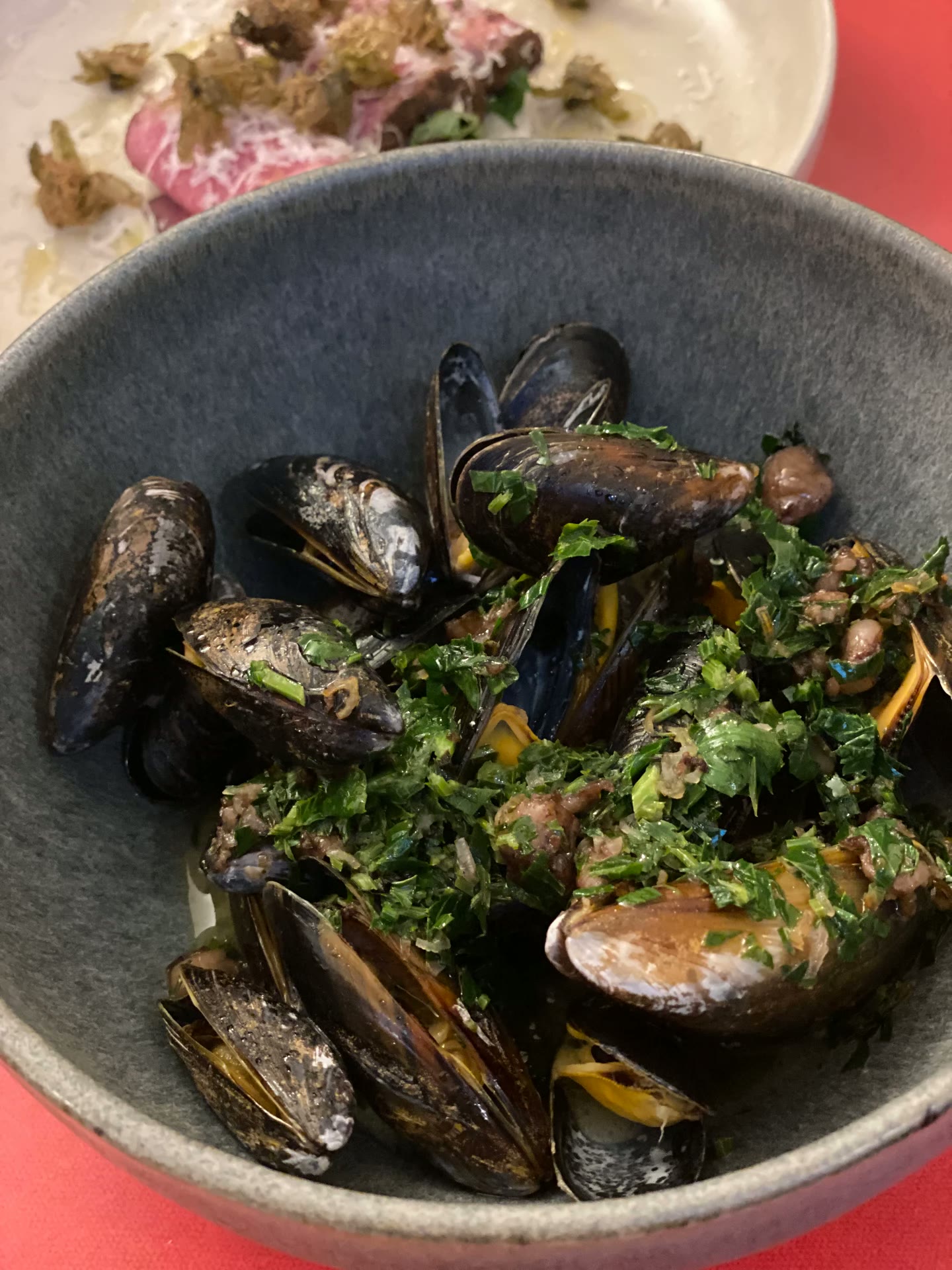 A bowl of mussels with herbs