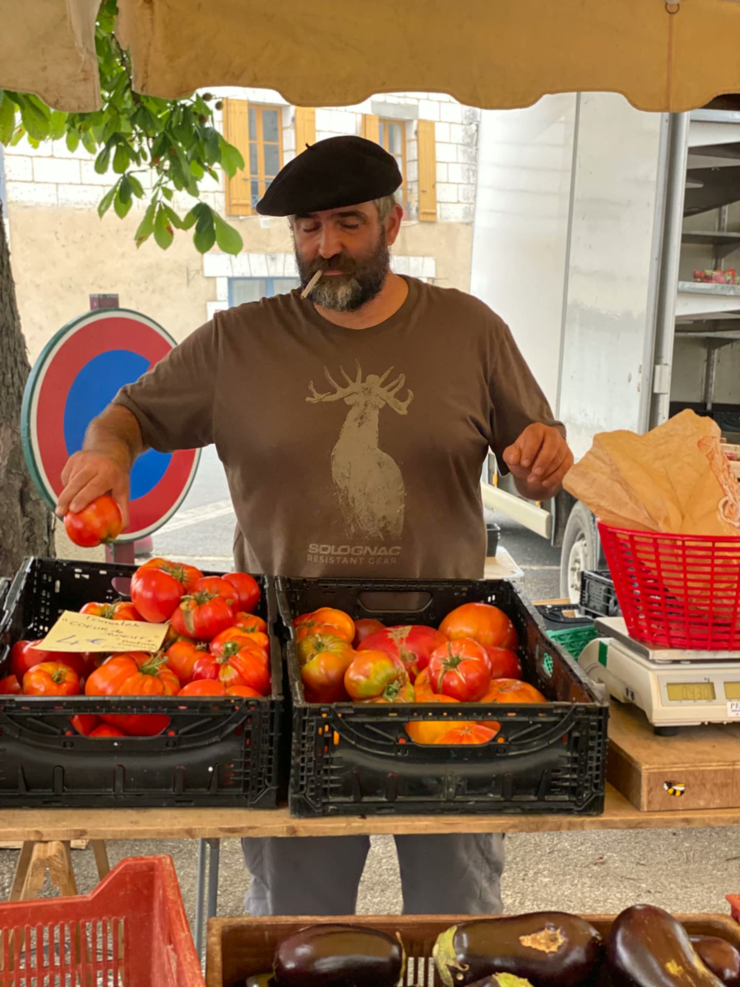 A market stallholder with crates of heirloom tomatoes